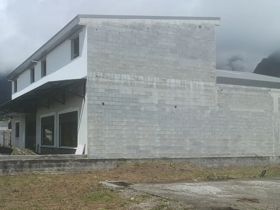 Le bâtiment du garage en construction, en 2025, sous les montagnes dans les nuages.