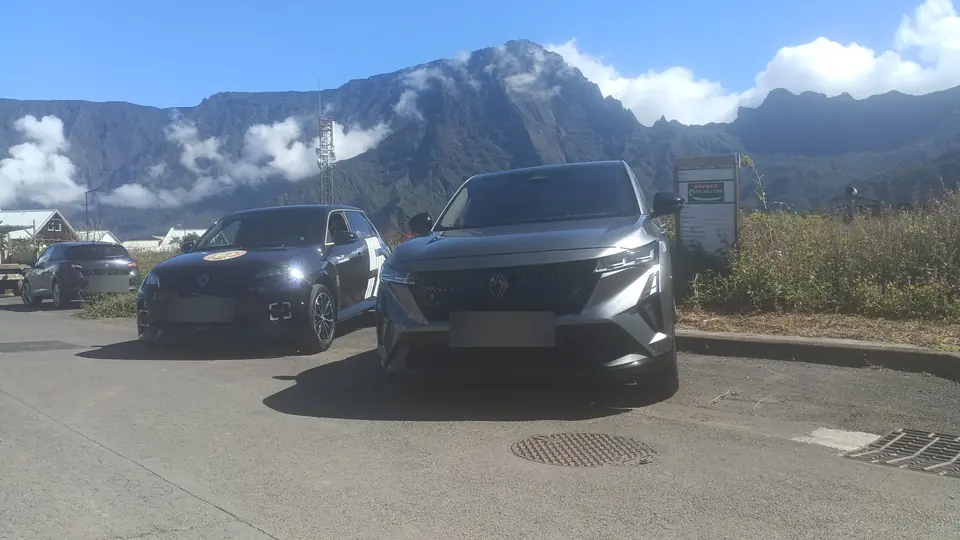 Les remparts du cirque de Cilaos sous le ciel bleu, au-dessus de deux voitures garées devant le garage.