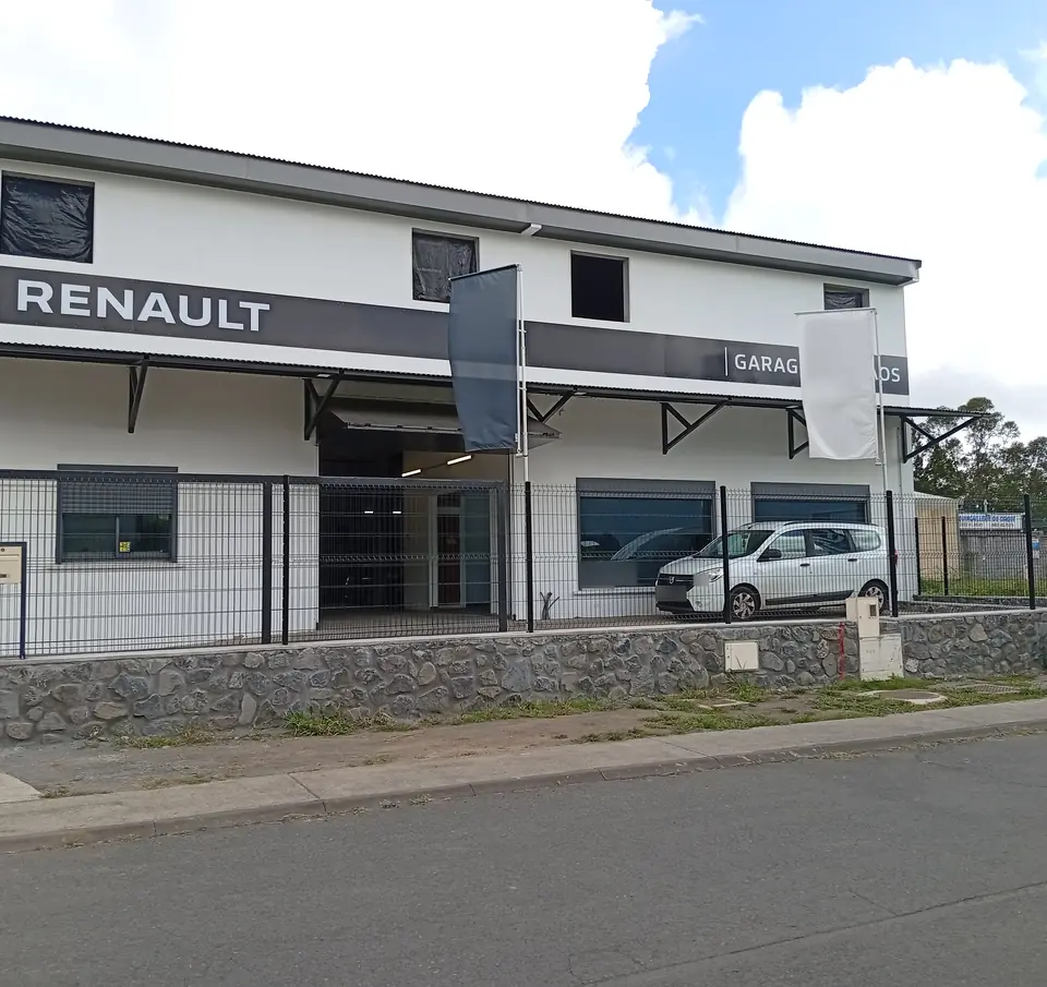 La façade des nouveaux locaux du garage, rue Raymond Vergès : enseigne Renault, muret en pierre et portail.